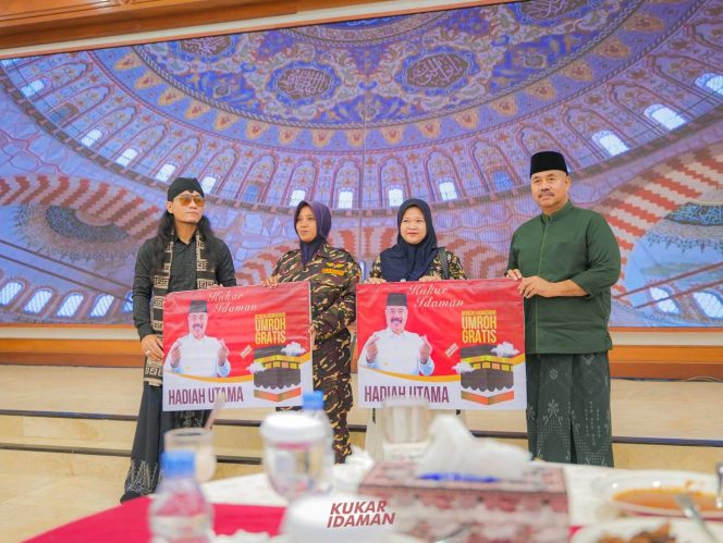 
Teks foto : Penyerahan doorprize umroh 