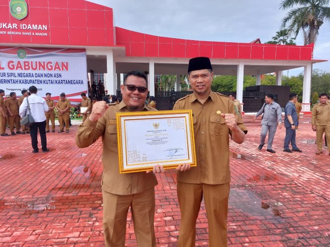
Teks foto : Kadis DPMD Kukar, Arianto bersama Sekdis Yusran Darma saat memegang Panji Keberhasilan Pembangunan Desa (istimewa) 