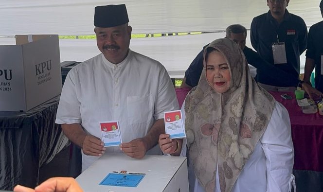 
Teks foto : Bupati Kukar Edi Damansyah dan istri memasukkan surat suara ke dalam kotak suara (angga/okeborneo.com) 