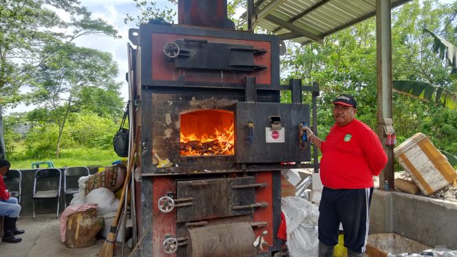
Petugas TPS3R Barokah Loa Kulu mengoperasikan tungku pembakaran sampah rumah tangga yang masuk setiap hari, Kamis (24/9/2025). (Angga/okeborneo.com)