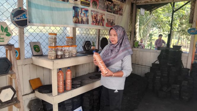 
Ketua Bank Sampah Sukamaju, Yayuk Sehati, menunjukkan botol berisi plastik daur ulang yang diolah menjadi paving blok ramah lingkungan. Inovasi ini menjadi solusi pengelolaan sampah di Desa Suka Maju. (Angga/okeborneo.com)