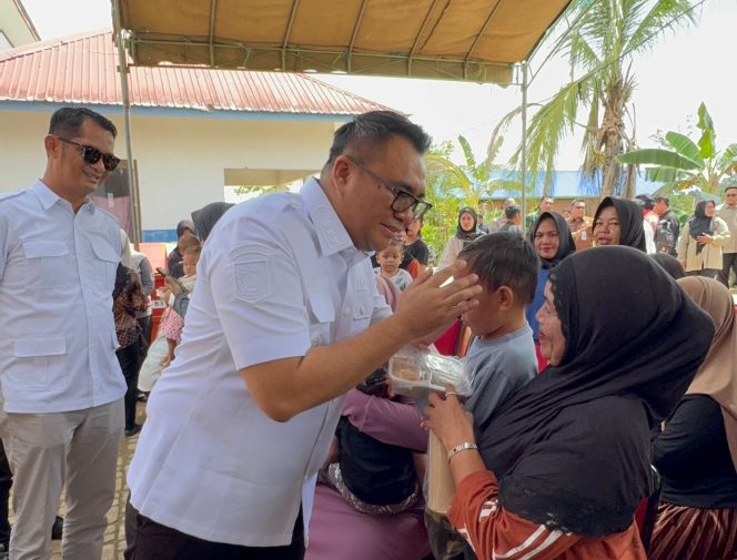 
Bupati Kukar Aulia Rahman Basri menyerahkan program makanan tambahan kepada warga saat kunjungan di Desa Sigihan. (Angga/okeborneo.com)