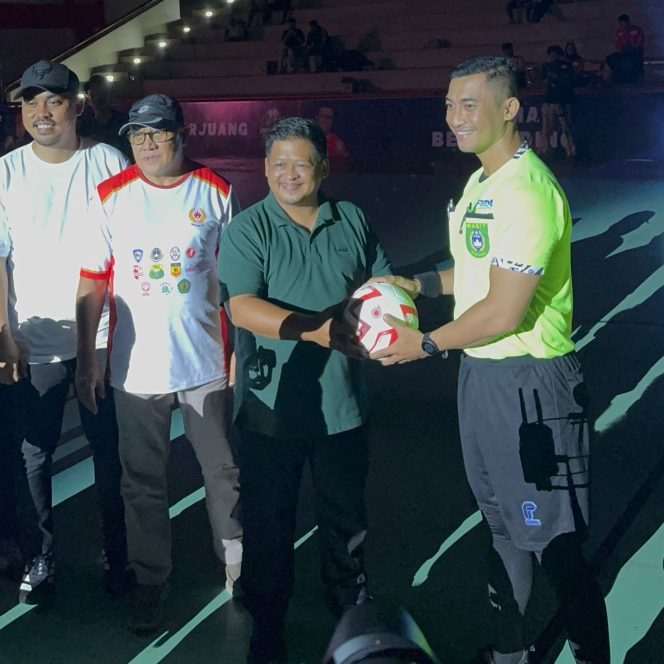 
Kepala Dispora Kukar menyerahkan bola pertandingan kepada panitia saat pembukaan Turnamen Futsal KNPI Cup 2025 (Angga/okeborneo.com).