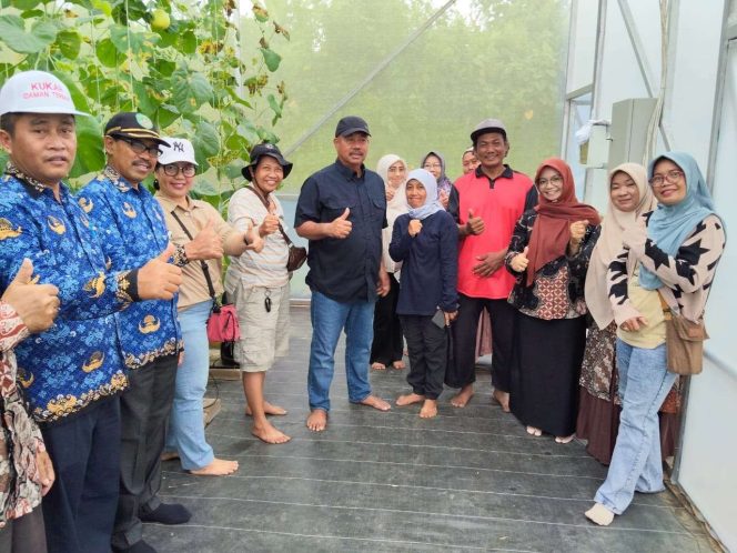 
Ketua KTNA Kukar, Edi Damansyah (tengah), bersama anggota KWT Wanita Mandiri berfoto usai panen perdana melon golden di Desa Rapak Lambur, Tenggarong. (Angga/okeborneo.com)