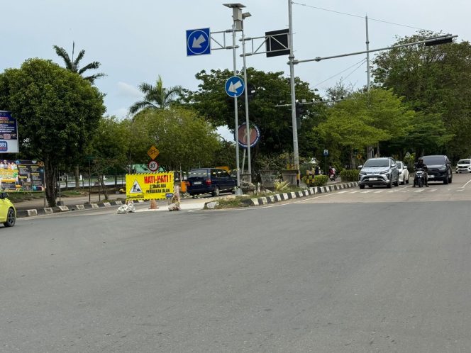 
Petugas memasang rambu peringatan di lokasi perbaikan jalan berlubang di kawasan Tenggarong. (Angga/okeborneo.com)