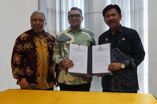 
Bupati Kutai Kartanegara Aulia Rahman Basri (tengah) menunjukkan dokumen LKPD 2025 saat penyerahan di Kantor BPK Kaltim. (Istimewa)