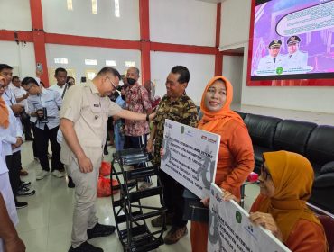 Bupati Kukar Aulia Rahman Basri menyerahkan bantuan sosial kepada veteran dan janda veteran dalam kegiatan penyaluran bantuan bagi kelompok rentan di BPU Tenggarong. (Istimewa)
