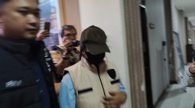 Tersangka kasus dugaan penipuan dan penggelapan dana Samarinda Half Marathon 2026, V alias NO, saat menjalani proses hukum di Polresta Samarinda. Polisi menyebut tersangka tidak ditahan karena pertimbangan penyidik, tetapi proses hukum tetap berjalan. (pep/okeborneo.com)
