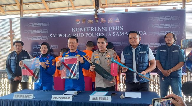 Petugas Satpolairud Polresta Samarinda menunjukkan barang bukti saat konferensi pers perkara dugaan pengeroyokan seorang ABK Tugboat Mahakam Indah di Pelabuhan Sungai Kunjang, Rabu, 15 Juli 2026. Empat tersangka turut dihadirkan dalam konferensi pers tersebut. (Budi Peppy/okeborneo.com)