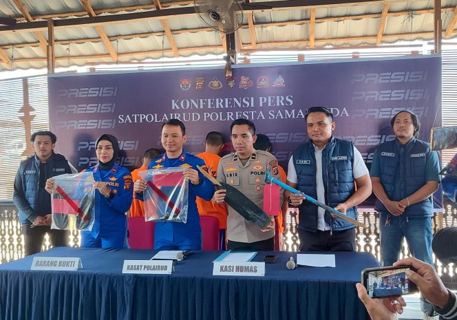 
Petugas Satpolairud Polresta Samarinda menunjukkan barang bukti saat konferensi pers perkara dugaan pengeroyokan seorang ABK Tugboat Mahakam Indah di Pelabuhan Sungai Kunjang, Rabu, 15 Juli 2026. Empat tersangka turut dihadirkan dalam konferensi pers tersebut. (Budi Peppy/okeborneo.com)