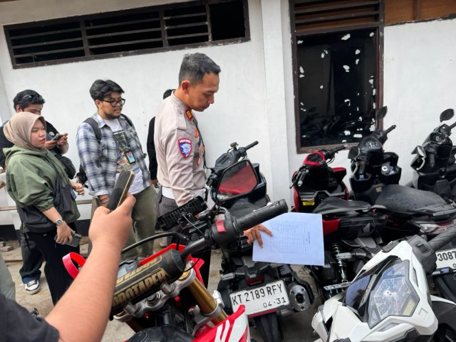 
Kasat Lantas Polres Kutai Kartanegara AKP Ahmad Fandoli memeriksa sepeda motor yang diamankan dalam penertiban balap liar di jalur poros Tenggarong–Samarinda. (Angga/okeborneo.com)