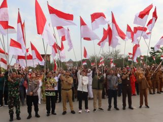 Bupati Kutai Kartanegara Aulia Rahman Basri bersama jajaran Forkopimda dan peserta mengibarkan bendera Merah Putih dalam Gerakan Nasional Pembagian dan Pemasangan Bendera Merah Putih di Tenggarong, Senin, 10 Agustus 2026. (angga/okeborneo.com)