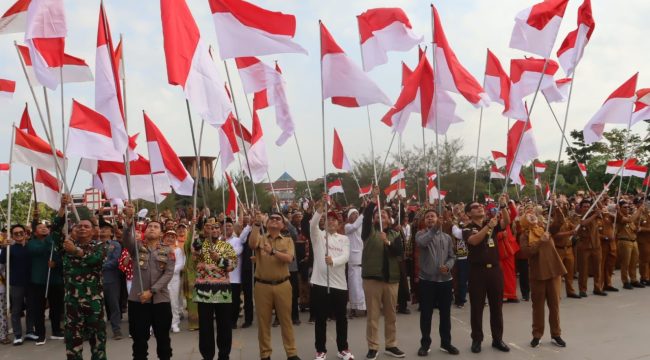 Bupati Kutai Kartanegara Aulia Rahman Basri bersama jajaran Forkopimda dan peserta mengibarkan bendera Merah Putih dalam Gerakan Nasional Pembagian dan Pemasangan Bendera Merah Putih di Tenggarong, Senin, 10 Agustus 2026. (angga/okeborneo.com)