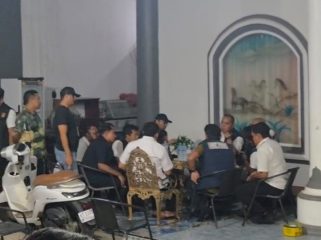 Sejumlah personel kepolisian berada di teras sebuah rumah yang digeledah di Kelurahan Melayu, Tenggarong, Rabu malam (5/8/2026). (Angga/okeborneo.com)