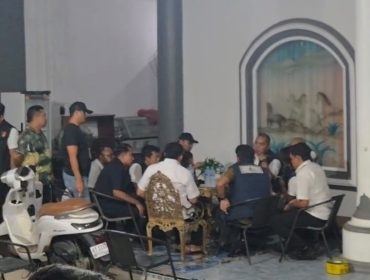 Sejumlah personel kepolisian berada di teras sebuah rumah yang digeledah di Kelurahan Melayu, Tenggarong, Rabu malam (5/8/2026). (Angga/okeborneo.com)