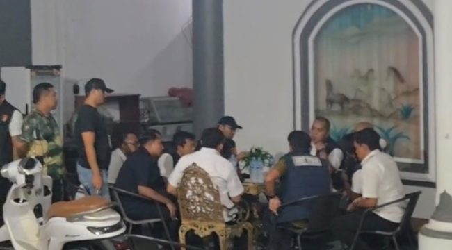 Sejumlah personel kepolisian berada di teras sebuah rumah yang digeledah di Kelurahan Melayu, Tenggarong, Rabu malam (5/8/2026). (Angga/okeborneo.com)