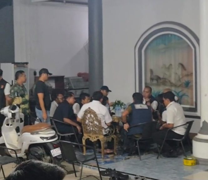 
Sejumlah personel kepolisian berada di teras sebuah rumah yang digeledah di Kelurahan Melayu, Tenggarong, Rabu malam (5/8/2026). (Angga/okeborneo.com)
